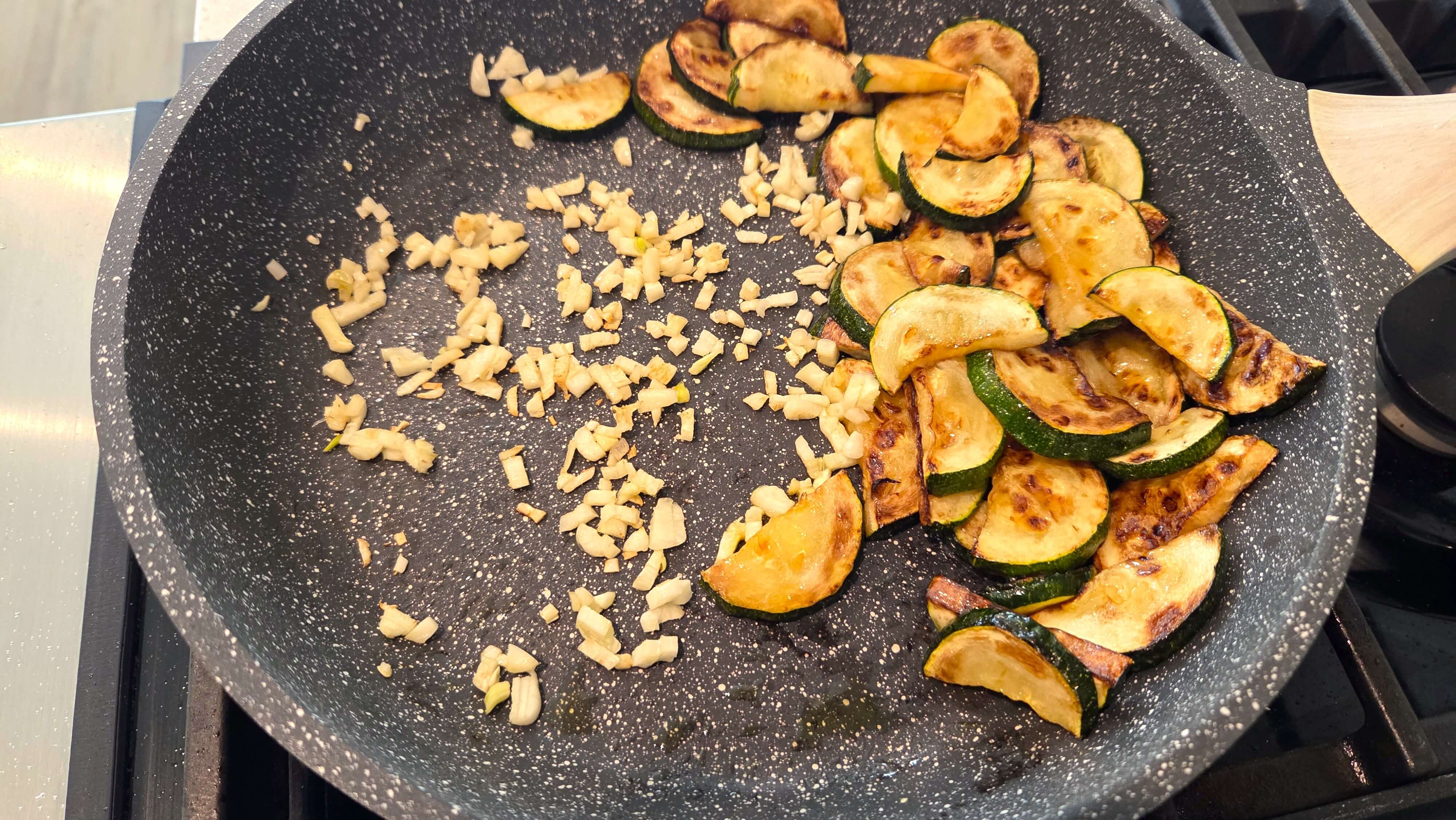Fresh garlic cooking with zucchini in a skillet for Mediterranean pasta