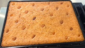 Freshly baked vegan basbousa with a golden brown top and almonds.