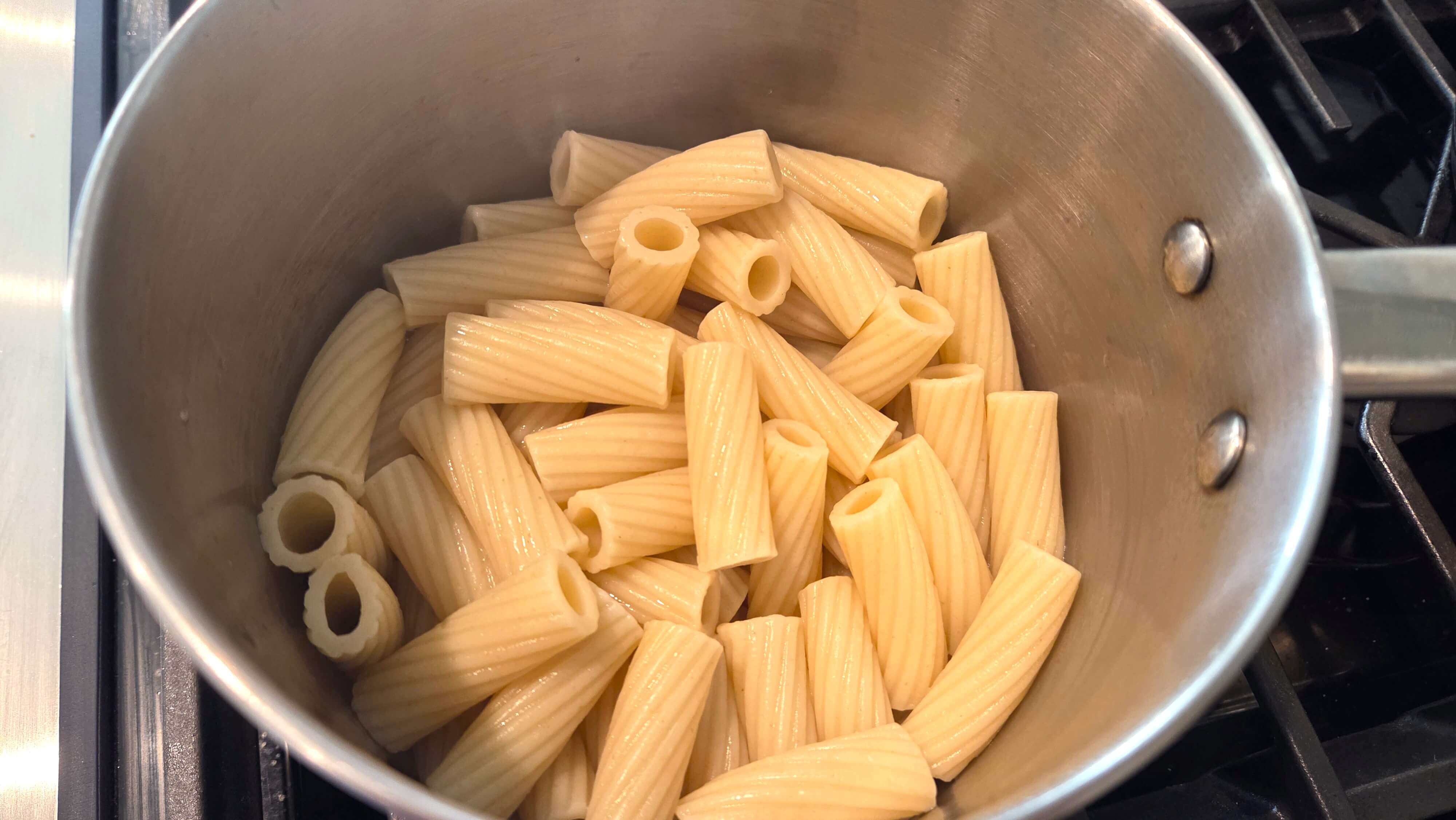 Cooking rigatoni pasta until al dente for the zucchini and cherry tomato pasta recipe.