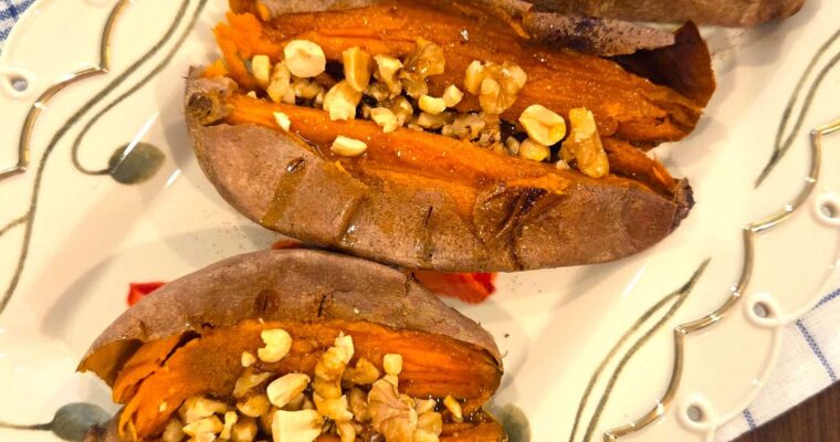 Easy baked sweet potato recipe with crispy skin served with honey, cinnamon, and chopped nuts