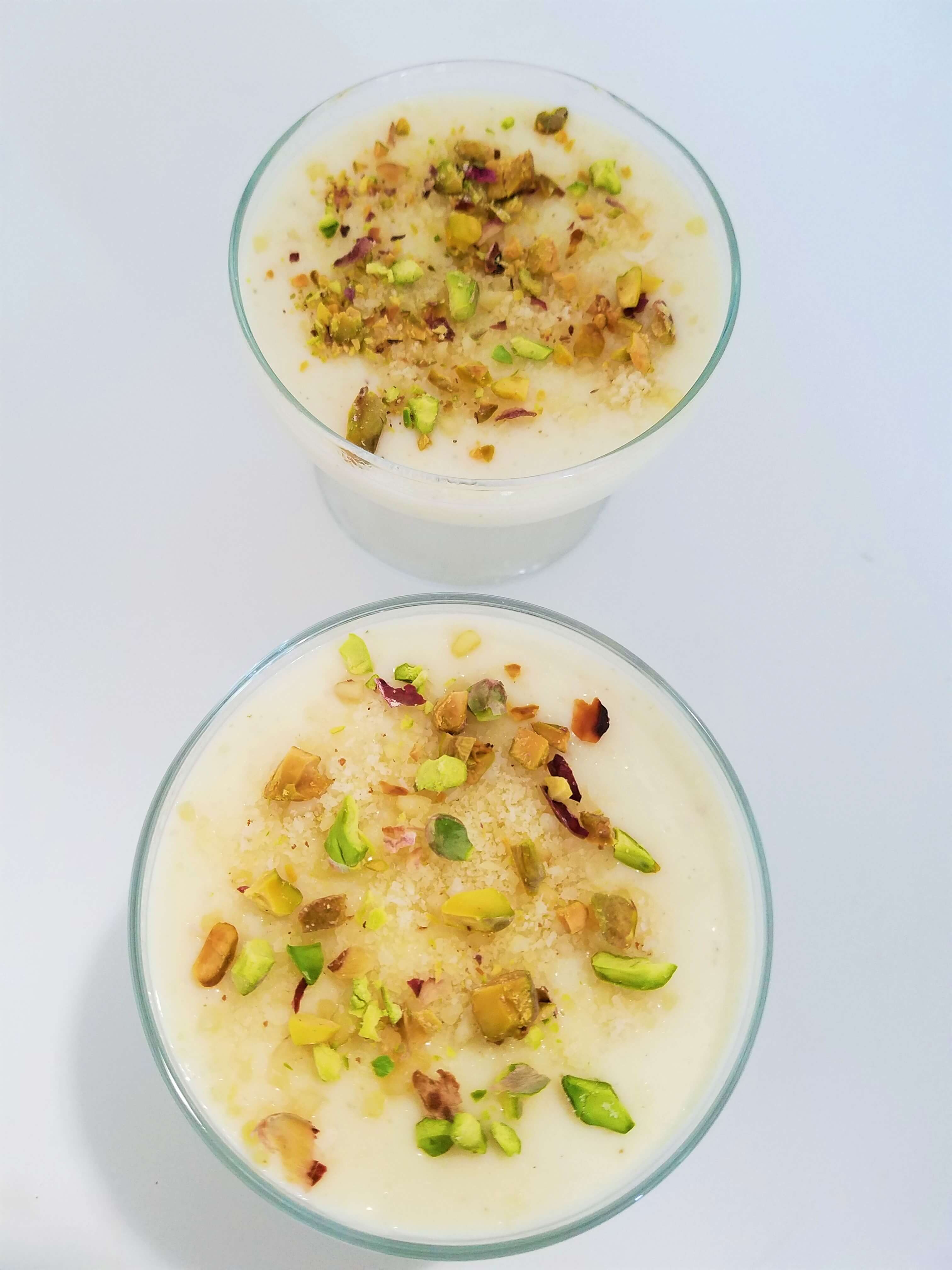 A beautiful close-up shot of an authentic bowl of easy Egyptian mahalabia highlighting the creamy texture and chopped pistachio topping.