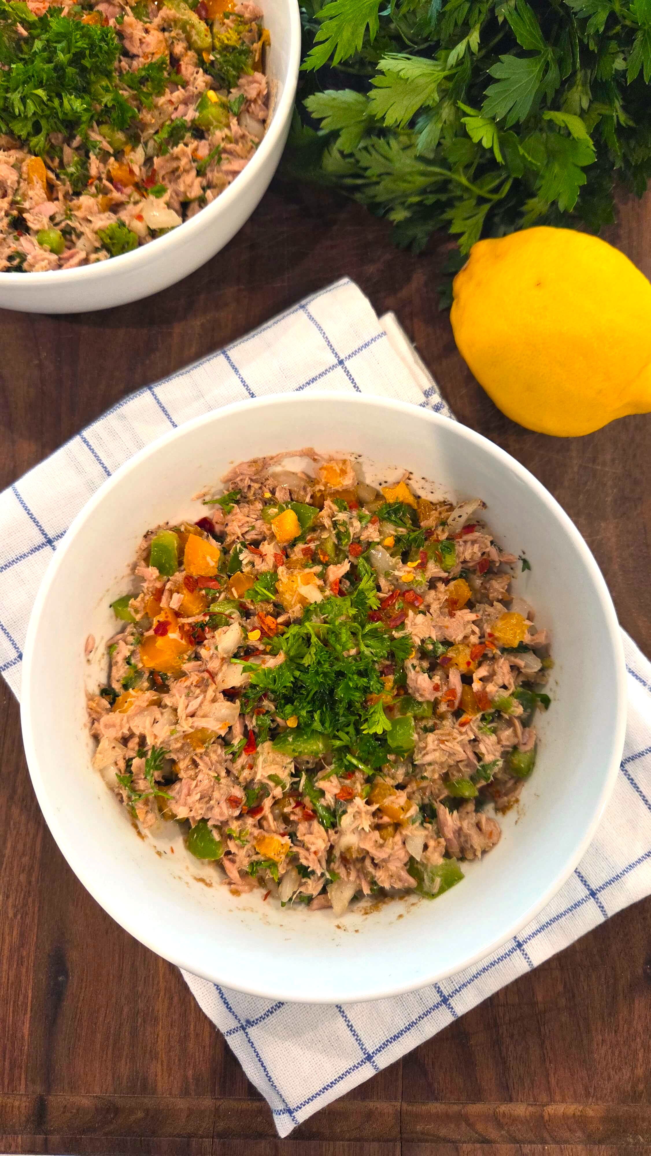 A premium close-up shot of a healthy no mayo Mediterranean tuna salad highlighting a light olive oil dressing and fresh green parsley garnish.