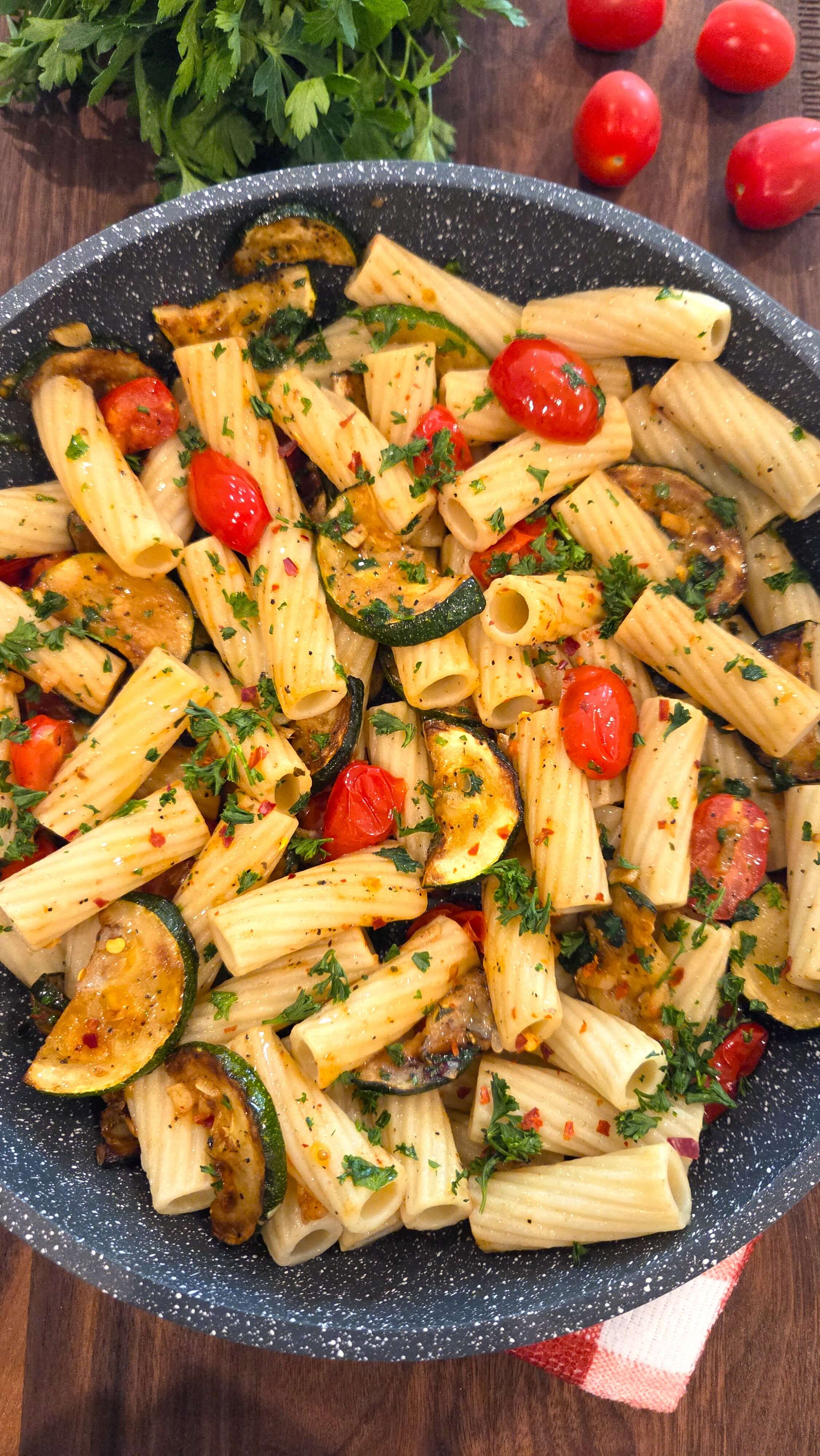 tomato pasta highlighting the glossy olive oil sauce and tender zucchini ribbons.