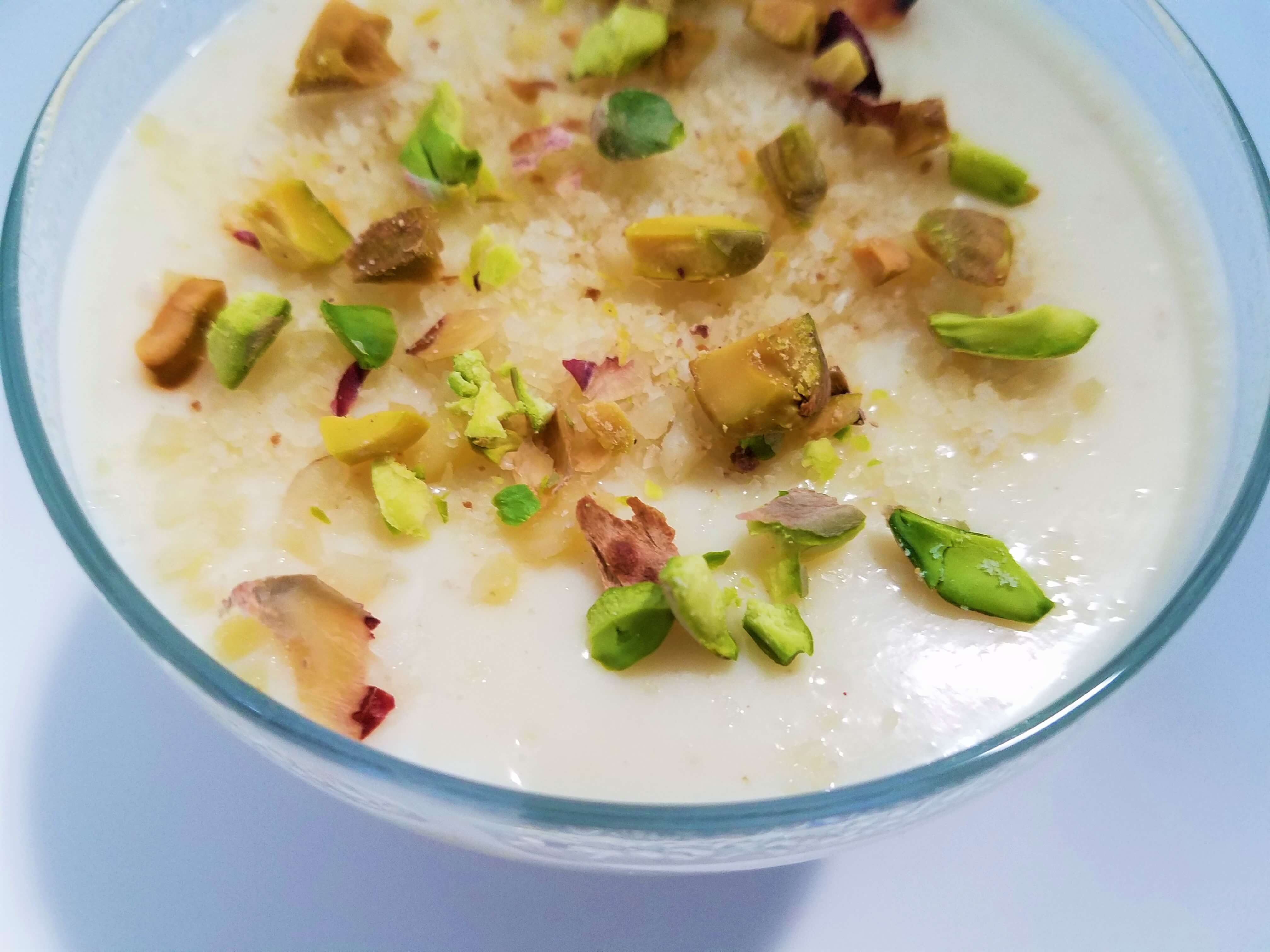 Egyptian mahalabia topped with chopped pistachios ready to serve