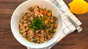 Healthy Mediterranean tuna salad without mayo mixed with fresh vegetables, herbs, olive oil, and Mediterranean spices.