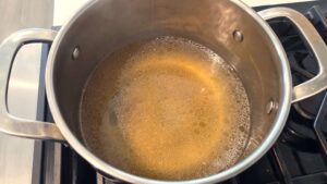 Chicken broth is heating in a pot for the Egyptian molokhia recipe