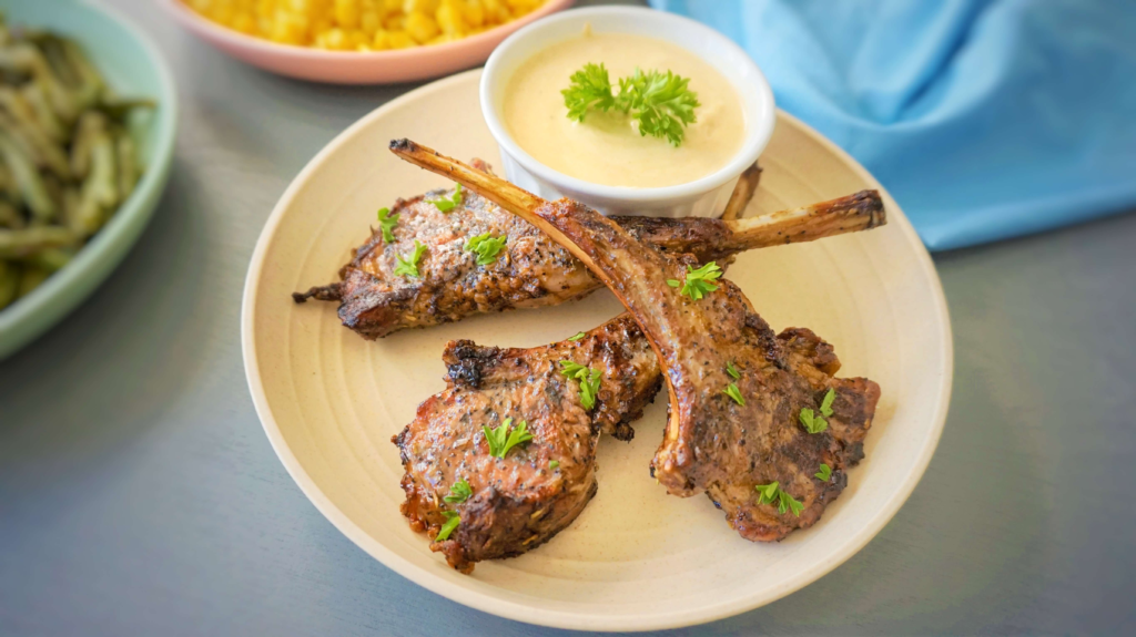 Juicy Mediterranean grilled lamb chops with a smoky char and parsley garnish served with tahini sauce.
