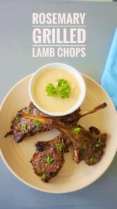 Mediterranean grilled lamb chops recipe served on a platter with fresh rosemary and parsley, served with tahini sauce