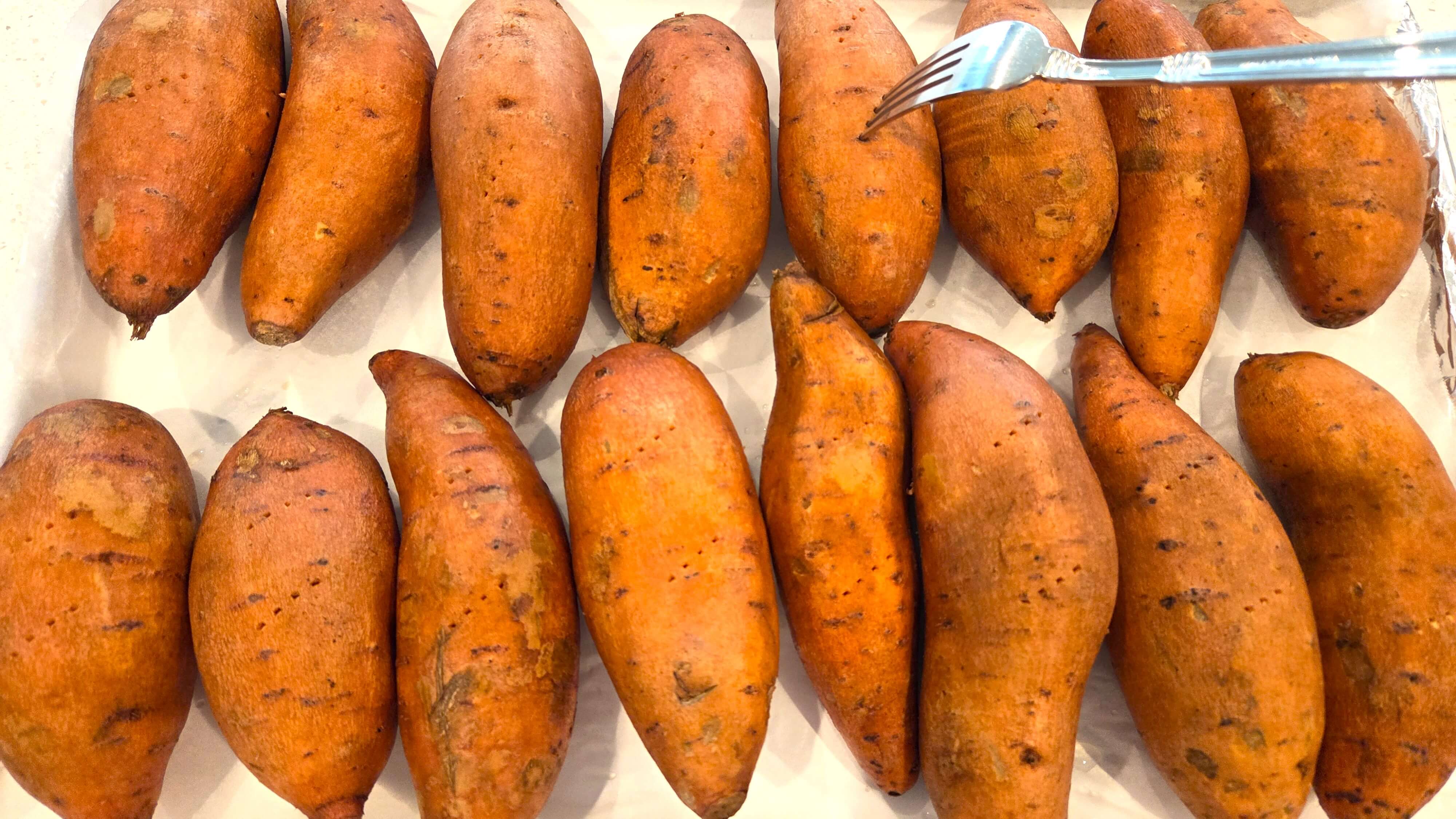 Piercing sweet potatoes with a fork before baking