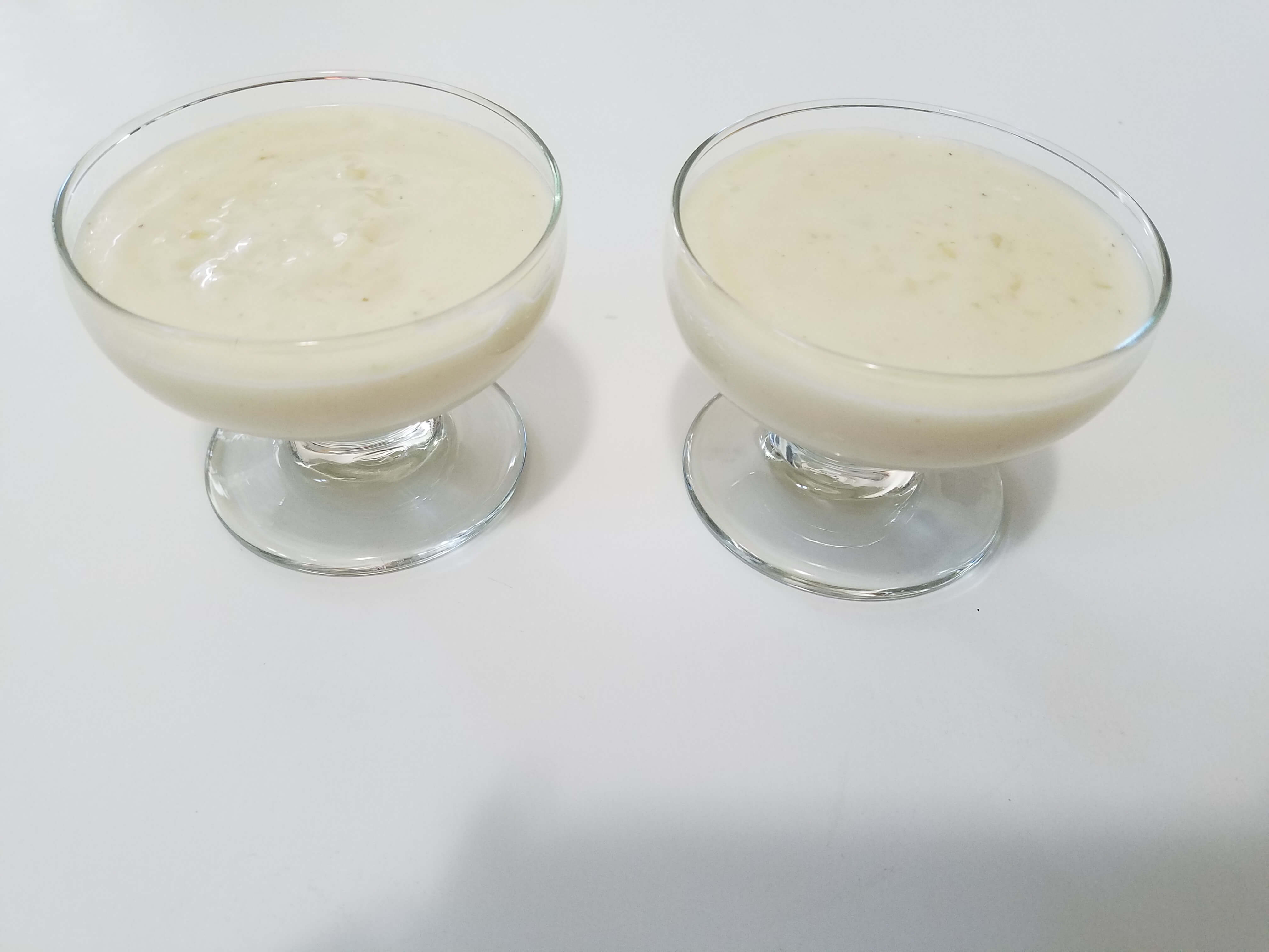 Pouring creamy Egyptian mahalabia into individual serving bowls