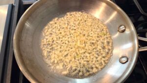 Minced garlic sautéing in butter and oil for traditional molokhia tasha