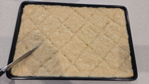 Vegan basbousa scored into diamonds before baking.