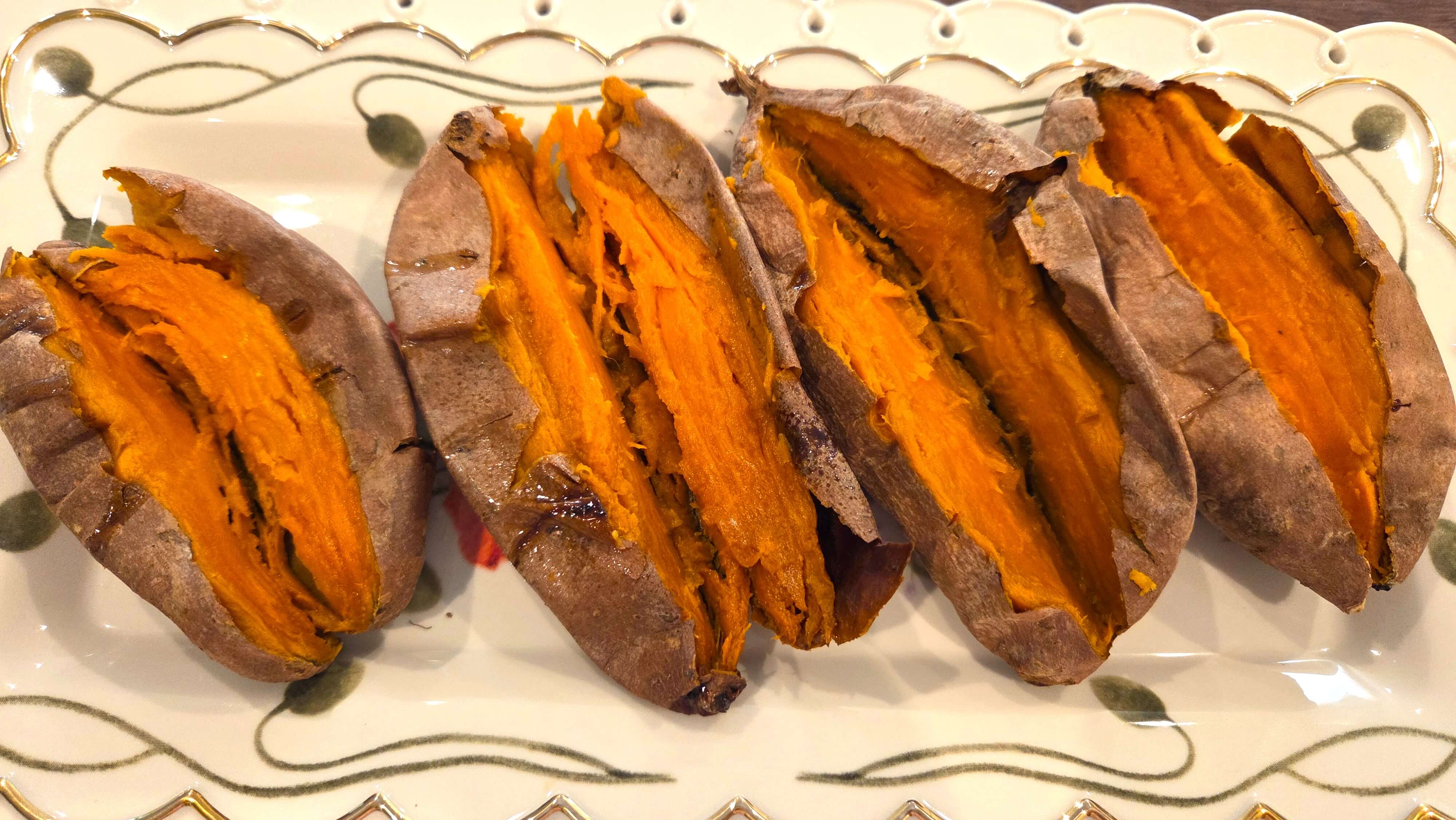 Slicing open baked sweet potatoes