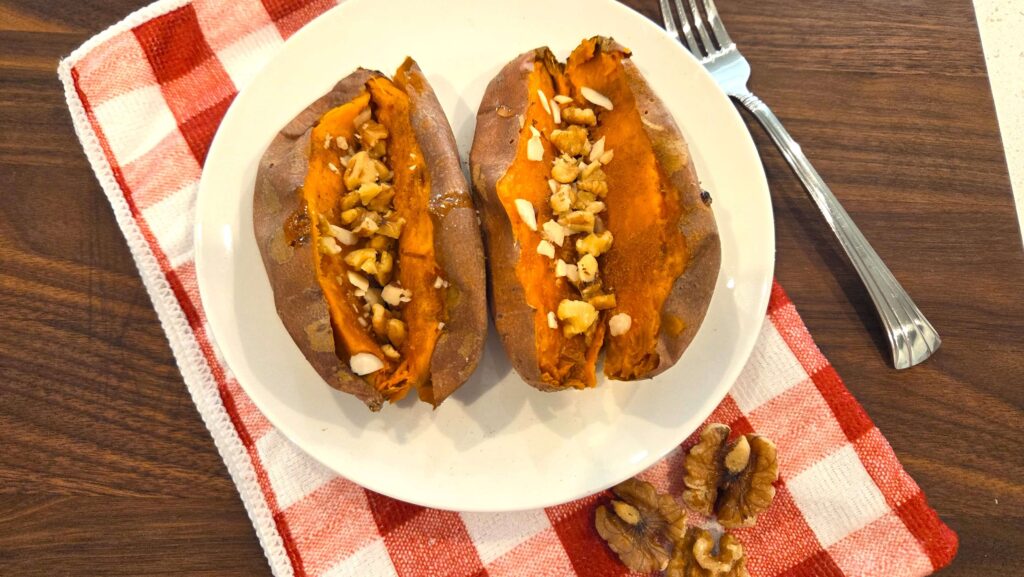 A top-down shot of baked sweet potatoes served with a warm drizzle of honey, ground cinnamon, and chopped walnuts.