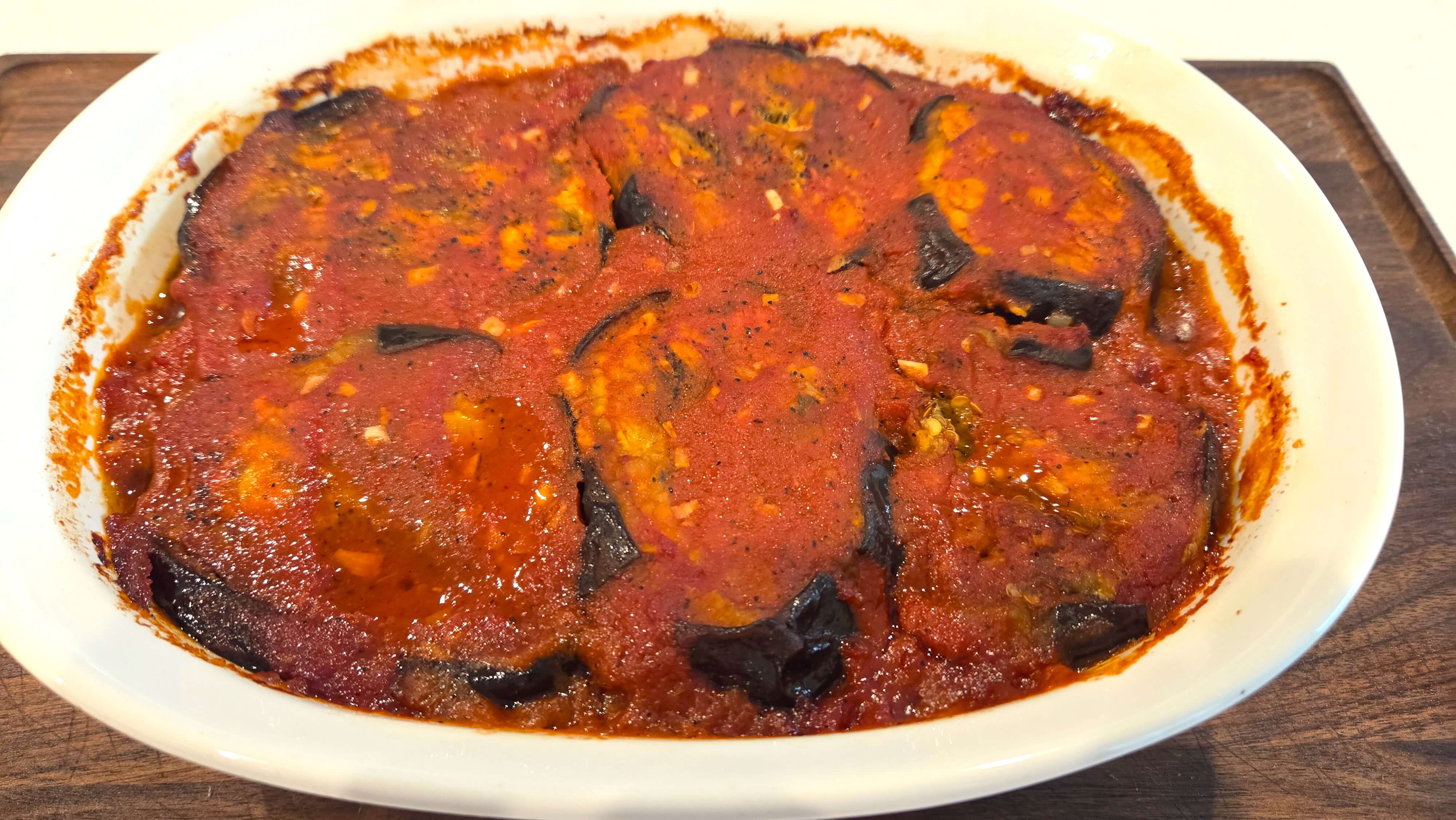 Baked Egyptian moussaka bubbling with tender eggplant, ground beef, green peppers, and tomato sauce.