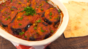 Egyptian moussaka with roasted eggplant, green bell peppers, ground beef, and tomato sauce.