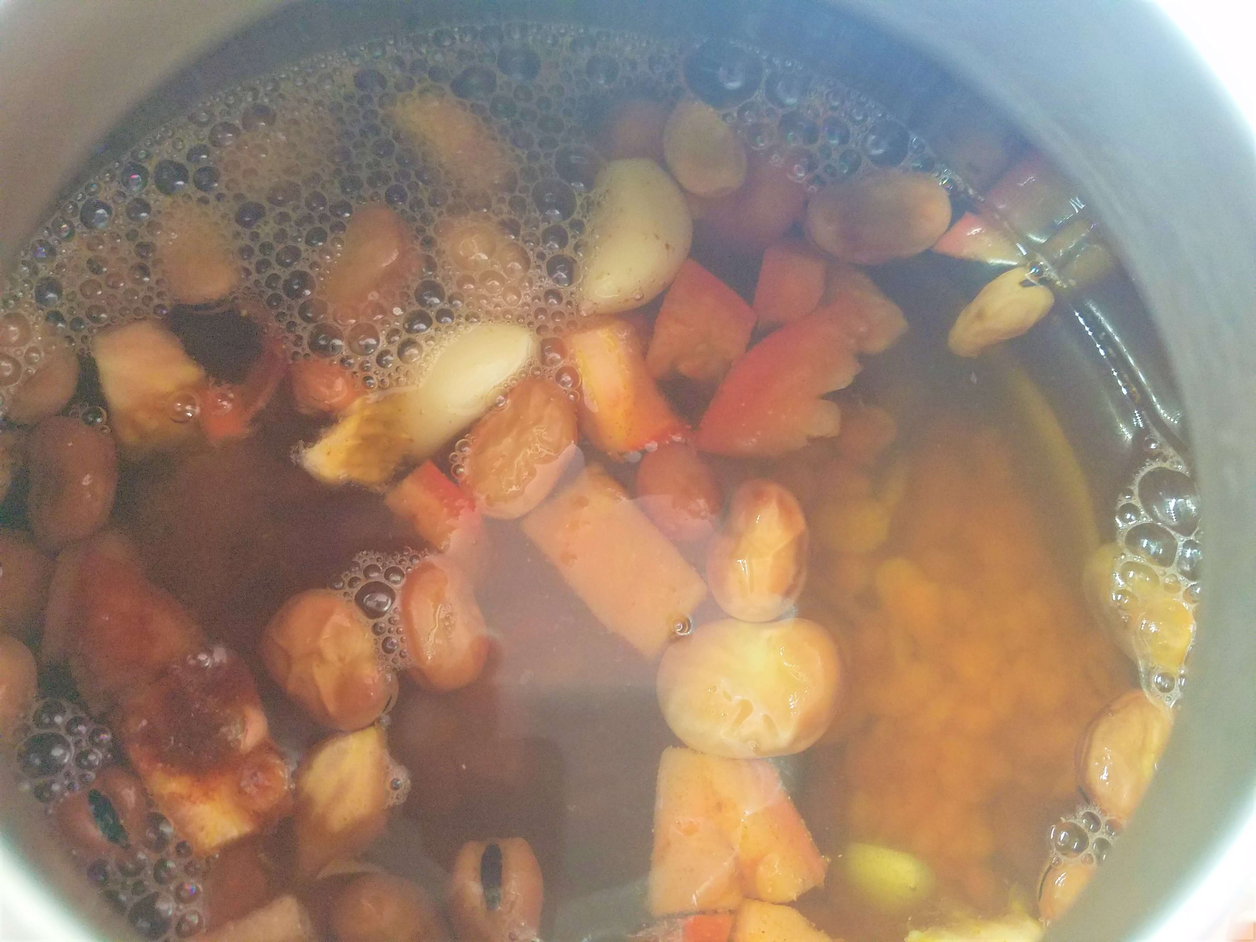A pot of Egyptian Ful Medames gently simmering and cooking down on a low burner.