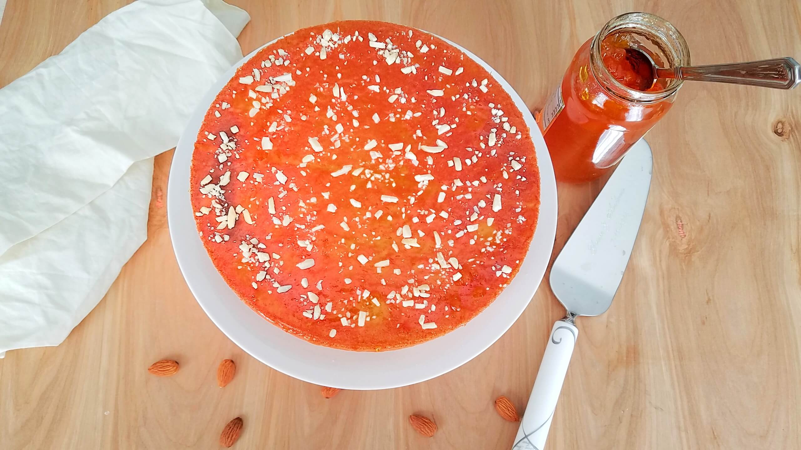 Apricot cake finished with glossy apricot jam and chopped almonds.