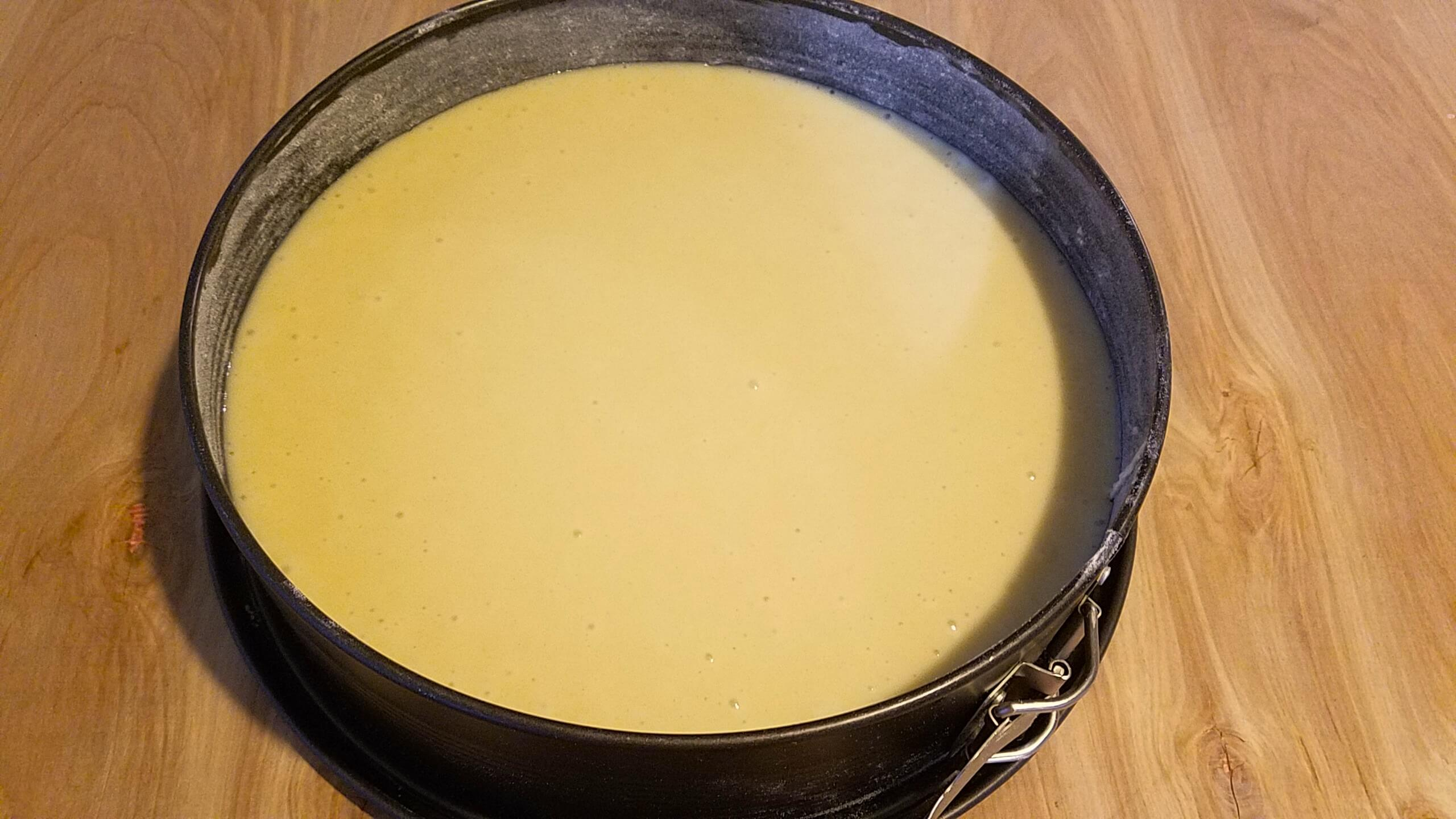 Moroccan apricot cake batter baking in a round cake pan until lightly golden.