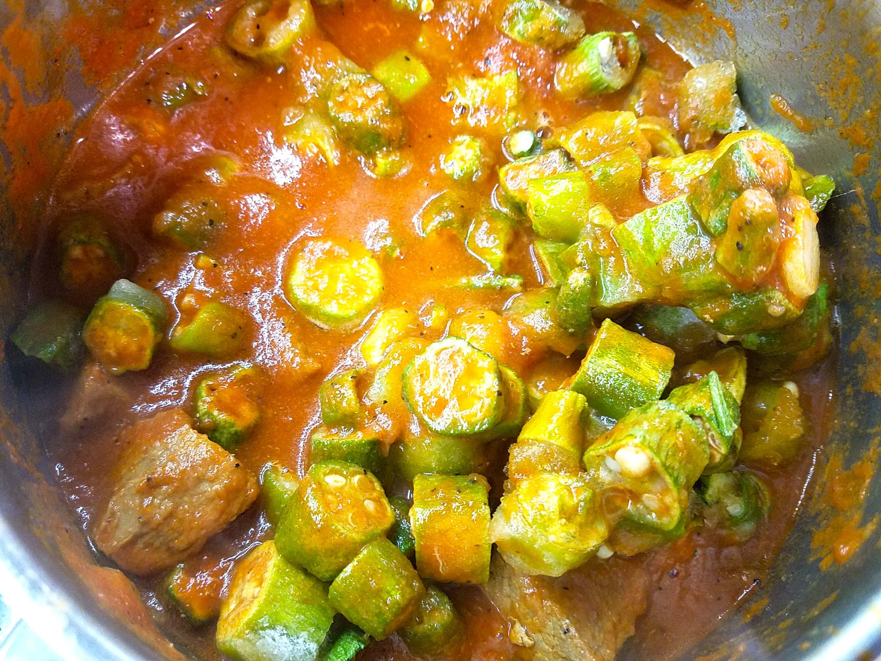 Frozen okra added to the beef and tomato stew for Bamya Bel Lahma
