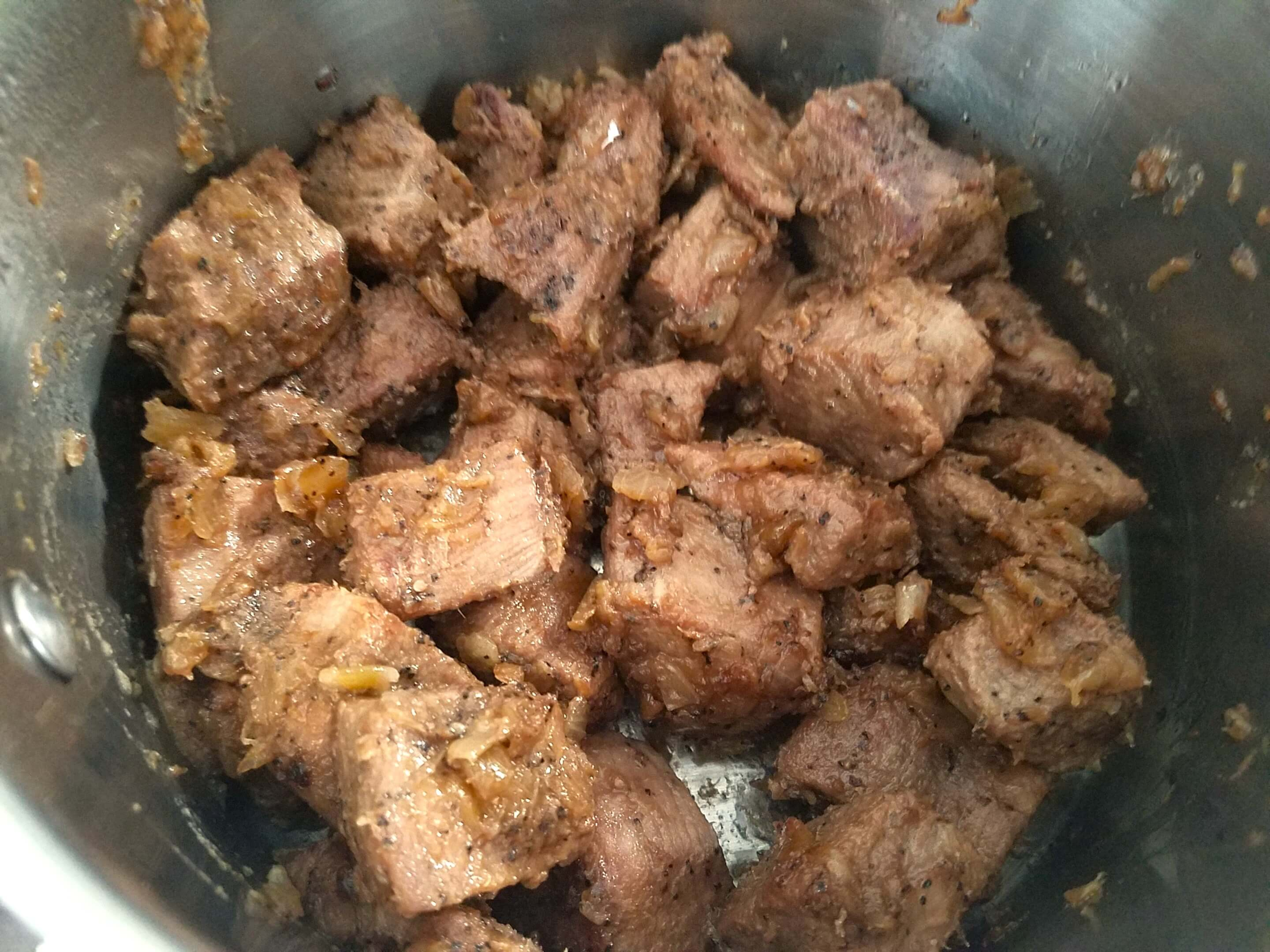 Beef cubes browning with garlic and spices