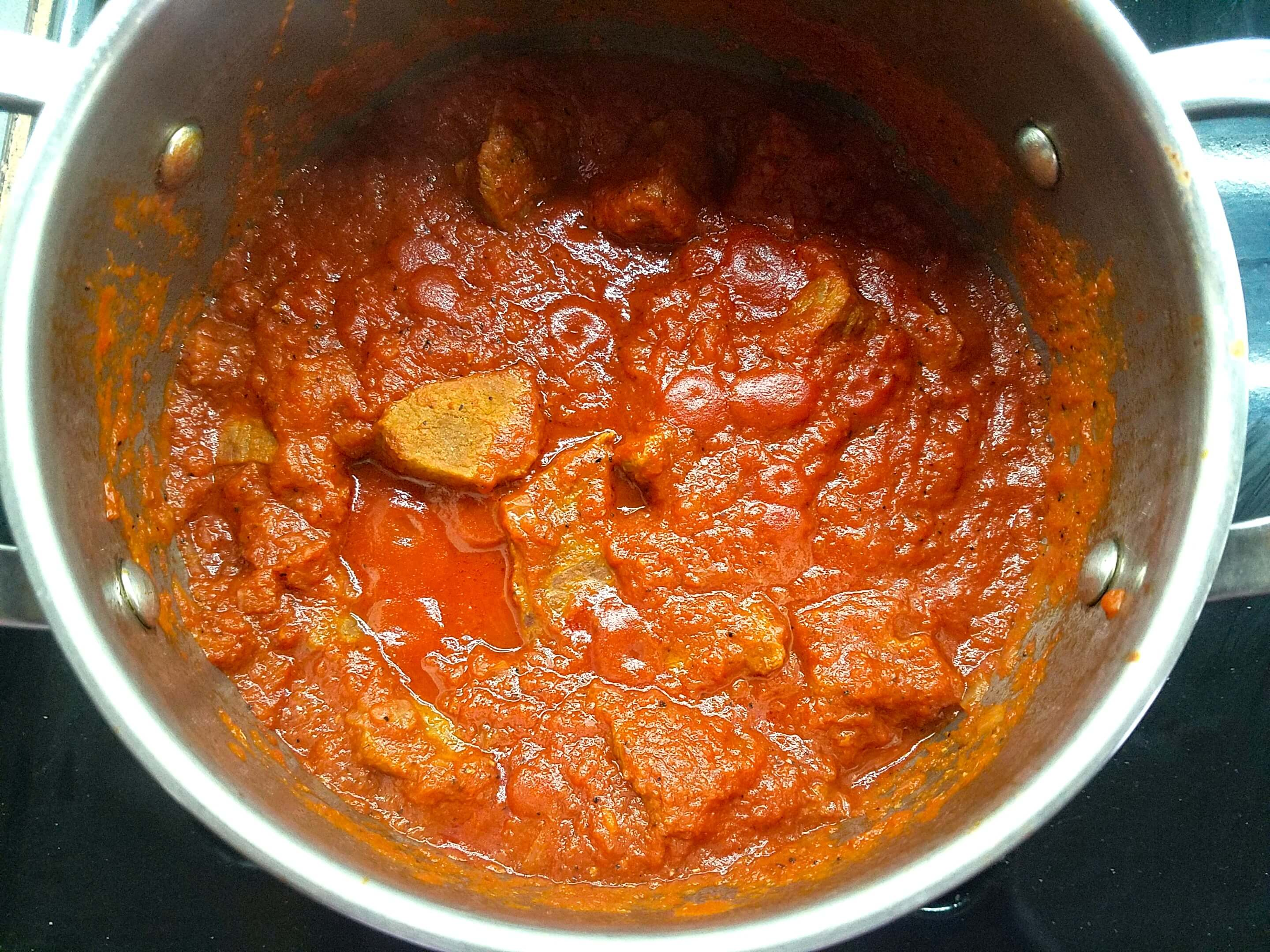 Beef simmering in tomato sauce for Egyptian Bamya