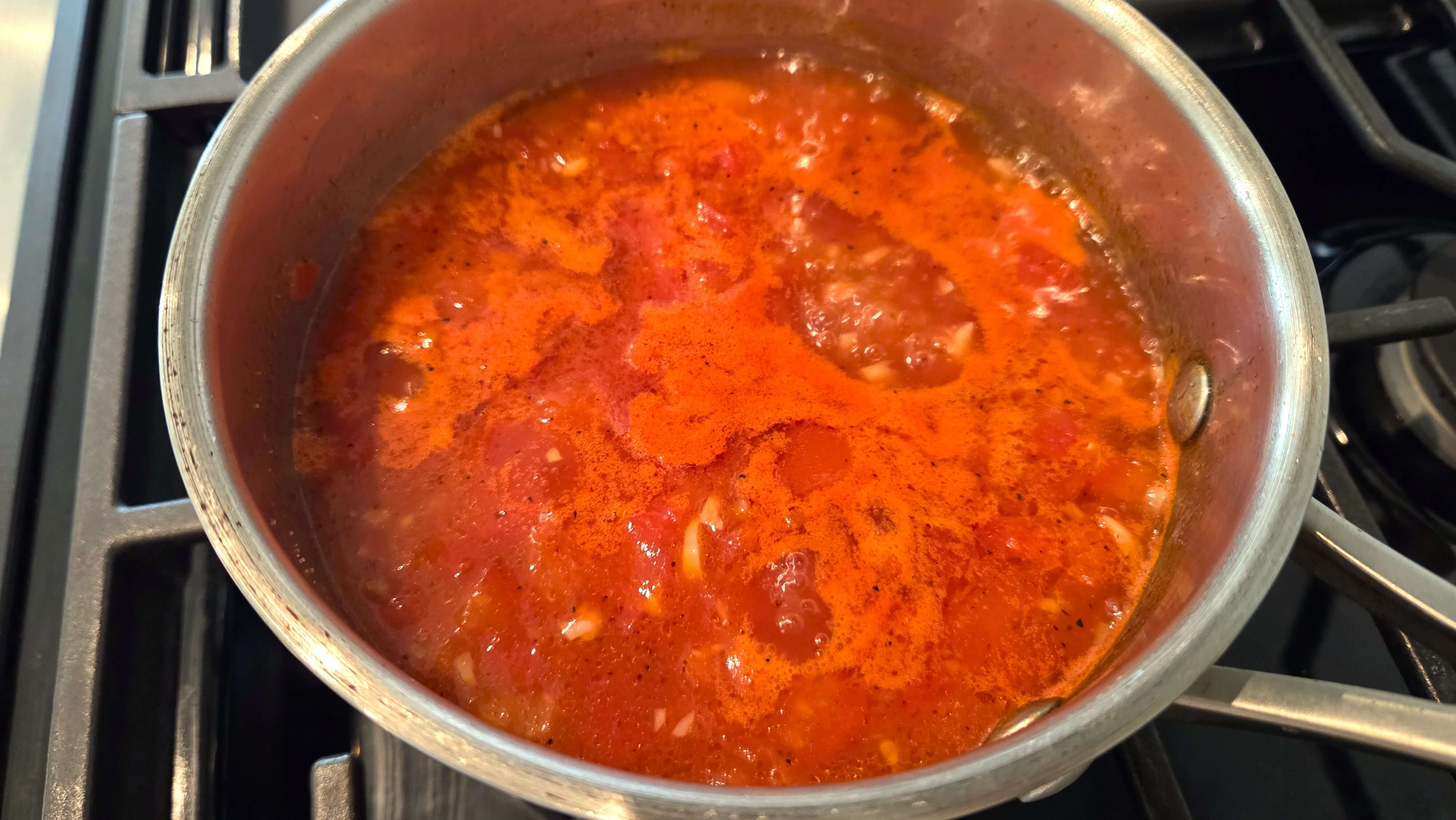 Garlic-vinegar tomato sauce simmering with tomatoes and beef broth for Fattah.