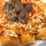 Authentic Egyptian Fattah with tender beef, vermicelli rice, crispy toasted bread, and garlic-vinegar tomato sauce.