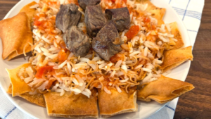 Authentic Egyptian Fattah with tender beef, vermicelli rice, crispy toasted bread, and garlic-vinegar tomato sauce.