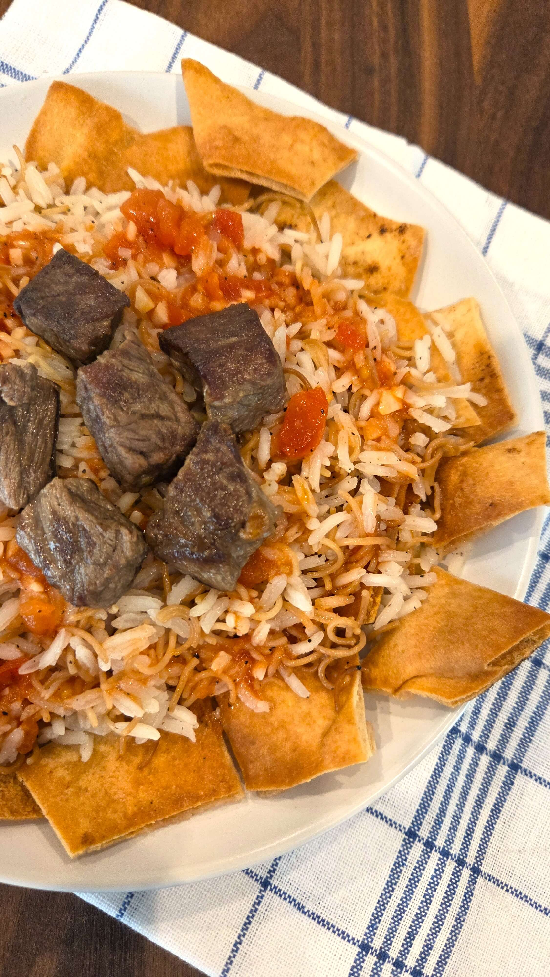 Egyptian Fattah recipe with browned beef, vermicelli rice, toasted bread, and garlic-vinegar tomato sauce.
