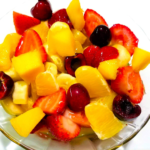 Fakhfakhina Egyptian fruit salad with mango, strawberries, oranges, cherries, banana, and mango juice.