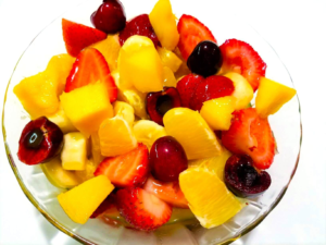 Fakhfakhina Egyptian fruit salad with mango, strawberries, oranges, cherries, banana, and mango juice.