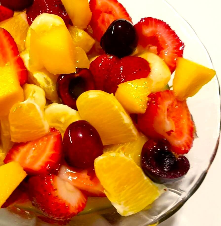 Chilled Fakhfakhina served in a glass with fresh fruit and mango juice.