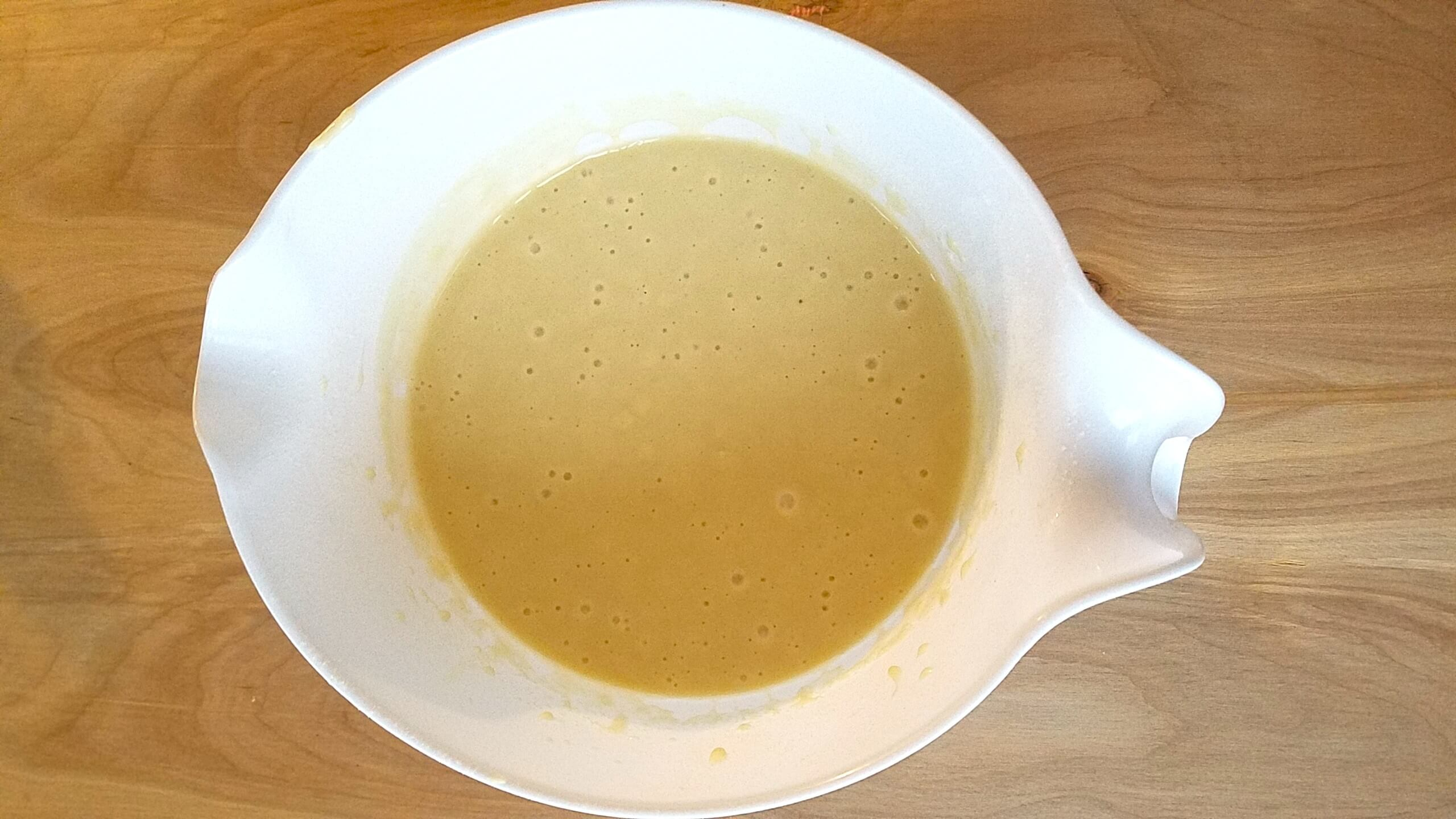 Flour, baking powder, and salt being mixed into the wet ingredients.