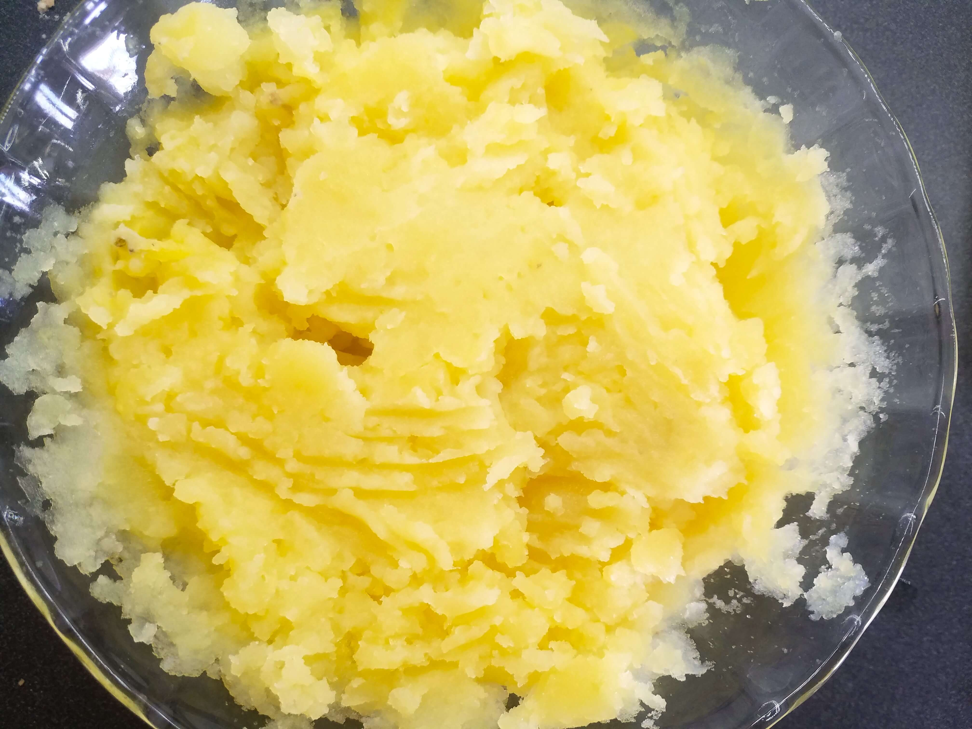 Boiled yellow potatoes mashed in a bowl.
