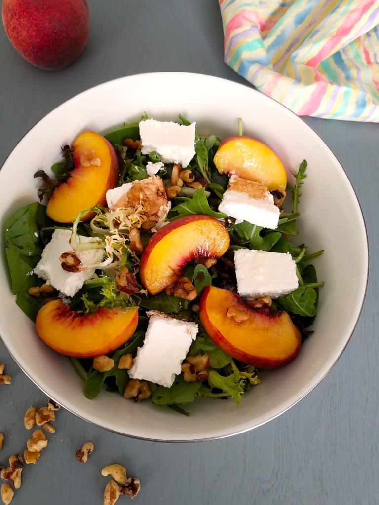 Fresh peach salad with feta, chopped walnuts, mixed greens, arugula, and mint.