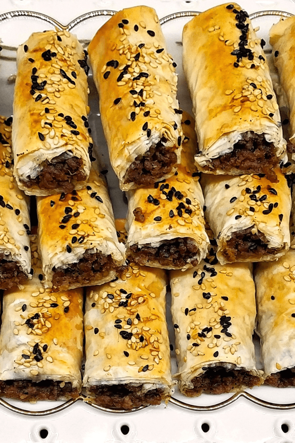 Homemade phyllo rolls with ground beef and topped with sesame and nigella seeds served warm