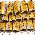 Crispy phyllo rolls filled with seasoned ground beef and topped with sesame and nigella seeds