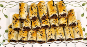 Crispy phyllo rolls filled with seasoned ground beef and topped with sesame and nigella seeds