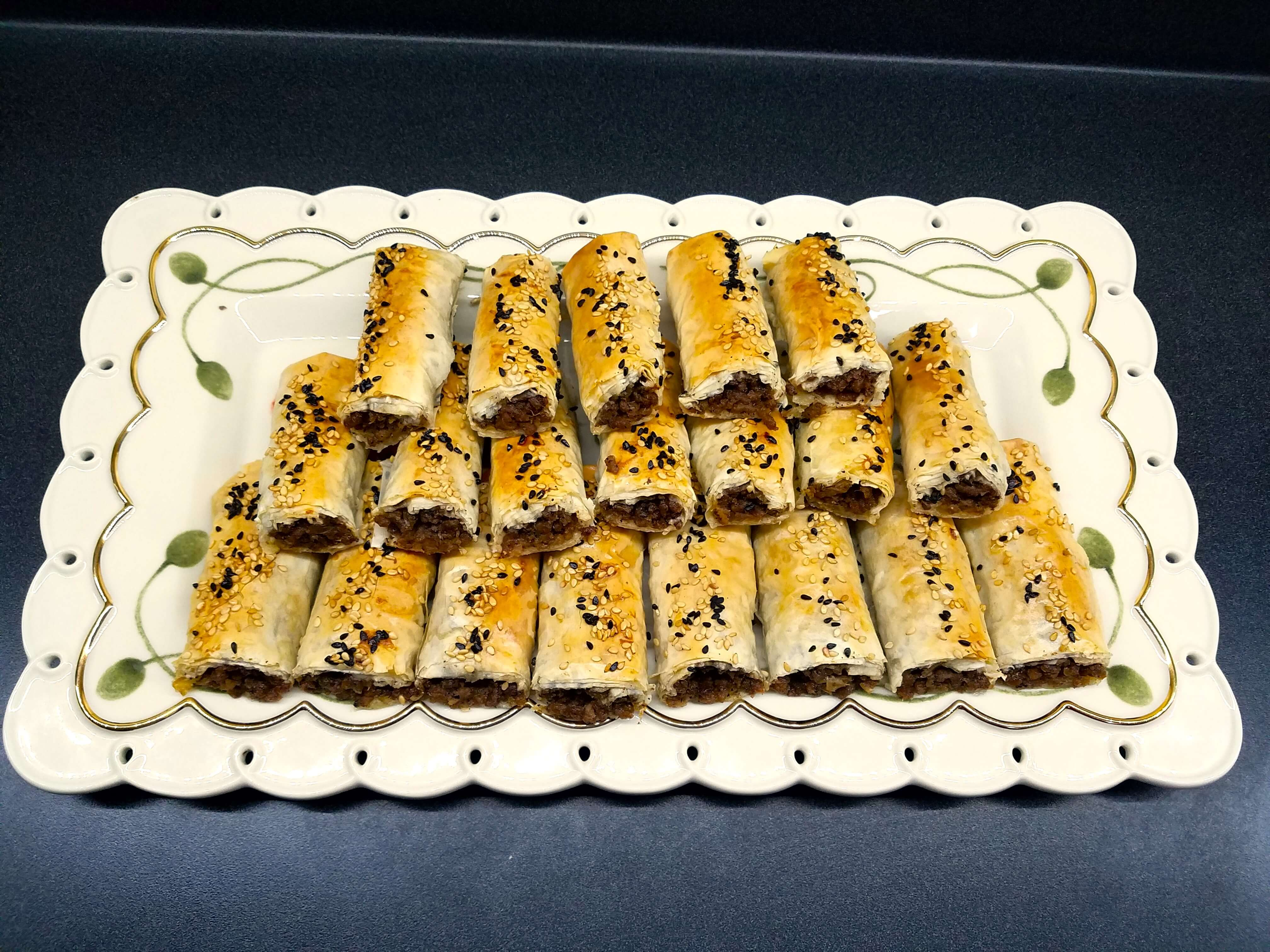 Warm crispy phyllo rolls with ground beef served on a platter