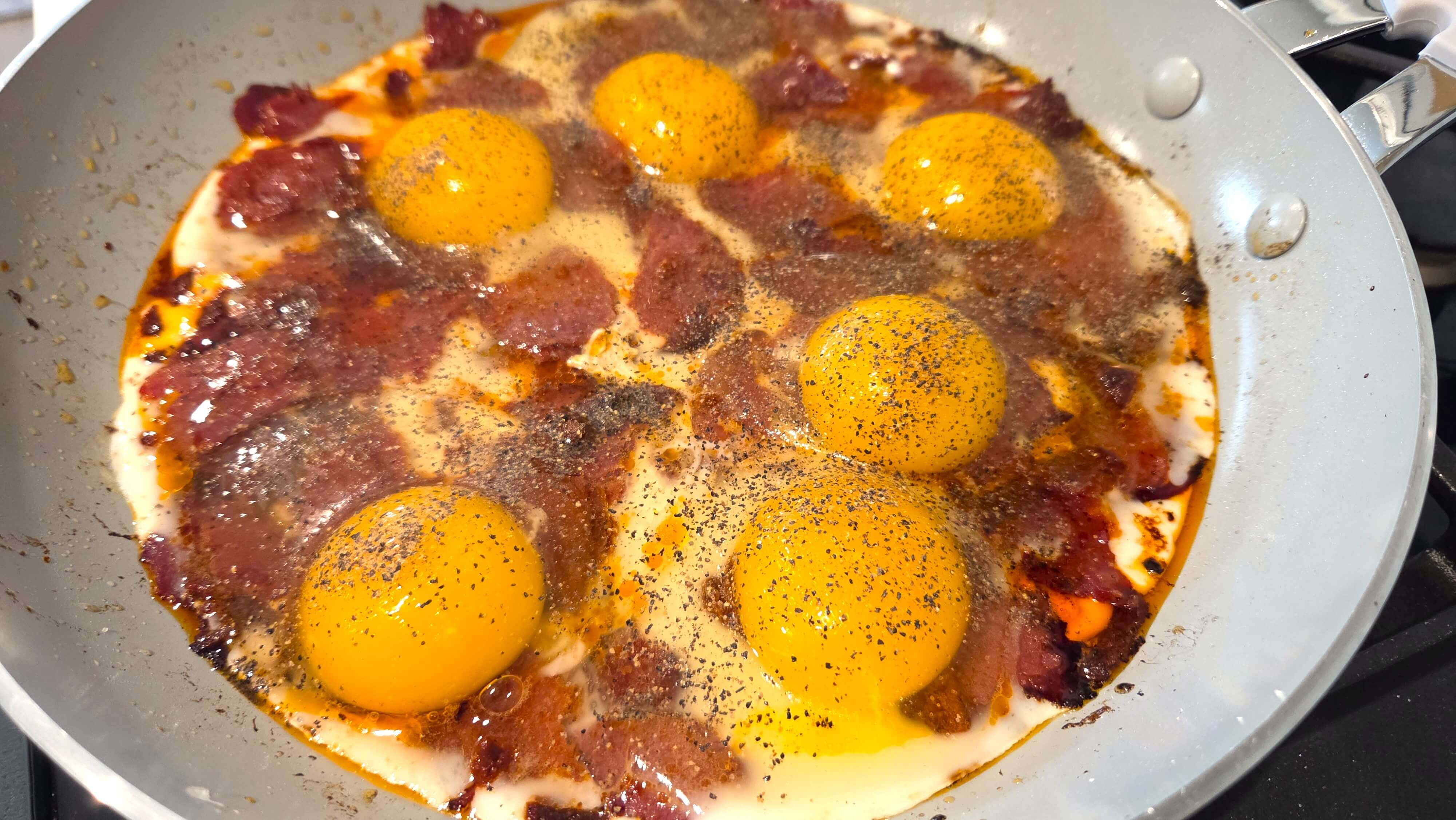 Eggs added to the skillet with cooked basturma