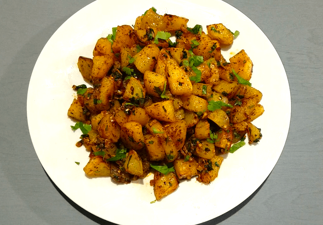 Crispy Batata Harra served with fresh lemon and chopped cilantro