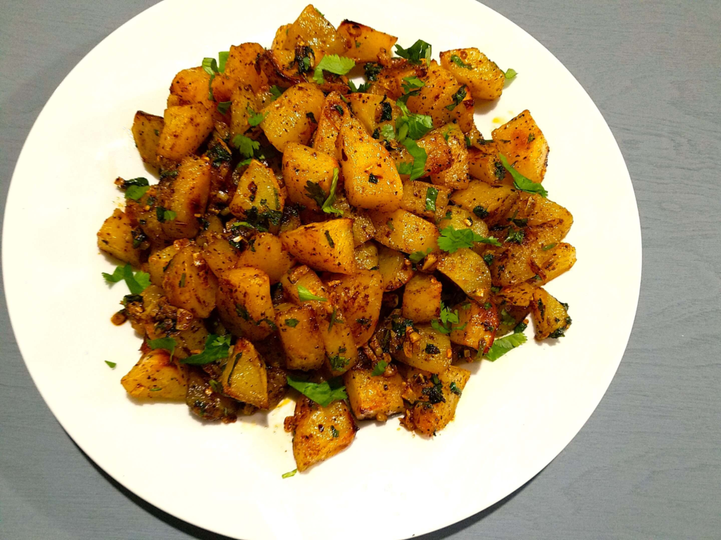 Crispy oven-baked Batata Harra tossed with garlic, red pepper flakes, and fresh cilantro