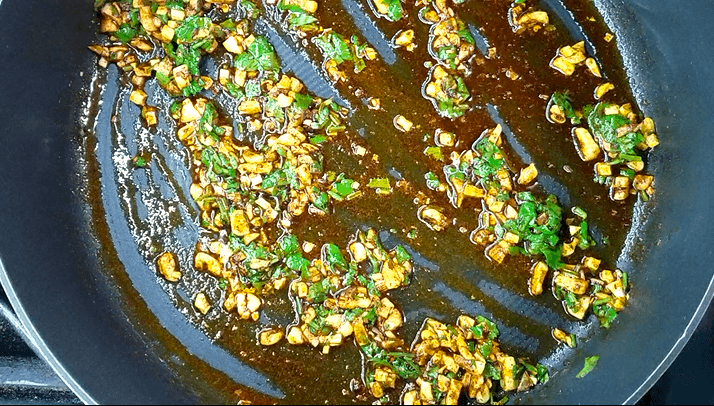 Fresh chopped cilantro stirred into warm garlic, red pepper flakes, and paprika
