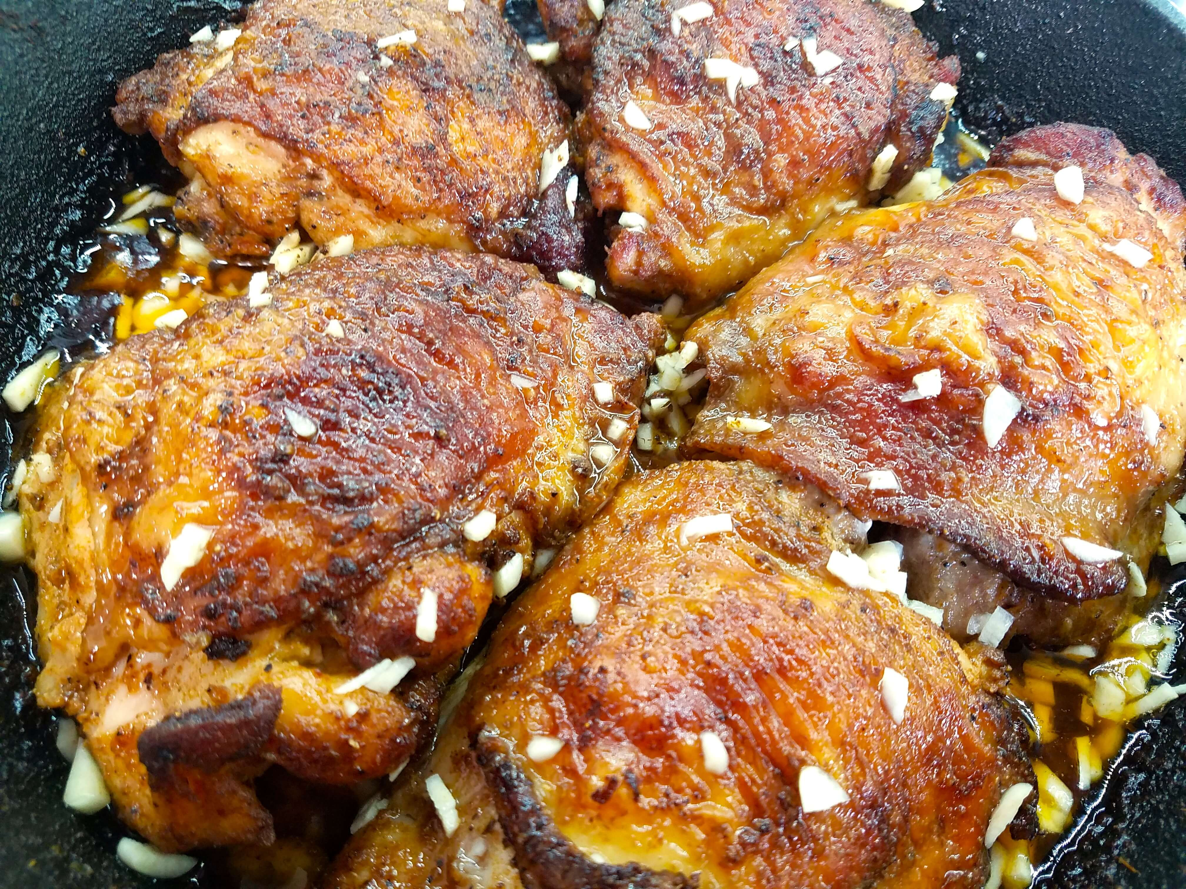 Lemon garlic chicken thighs finishing in the oven in a cast iron skillet