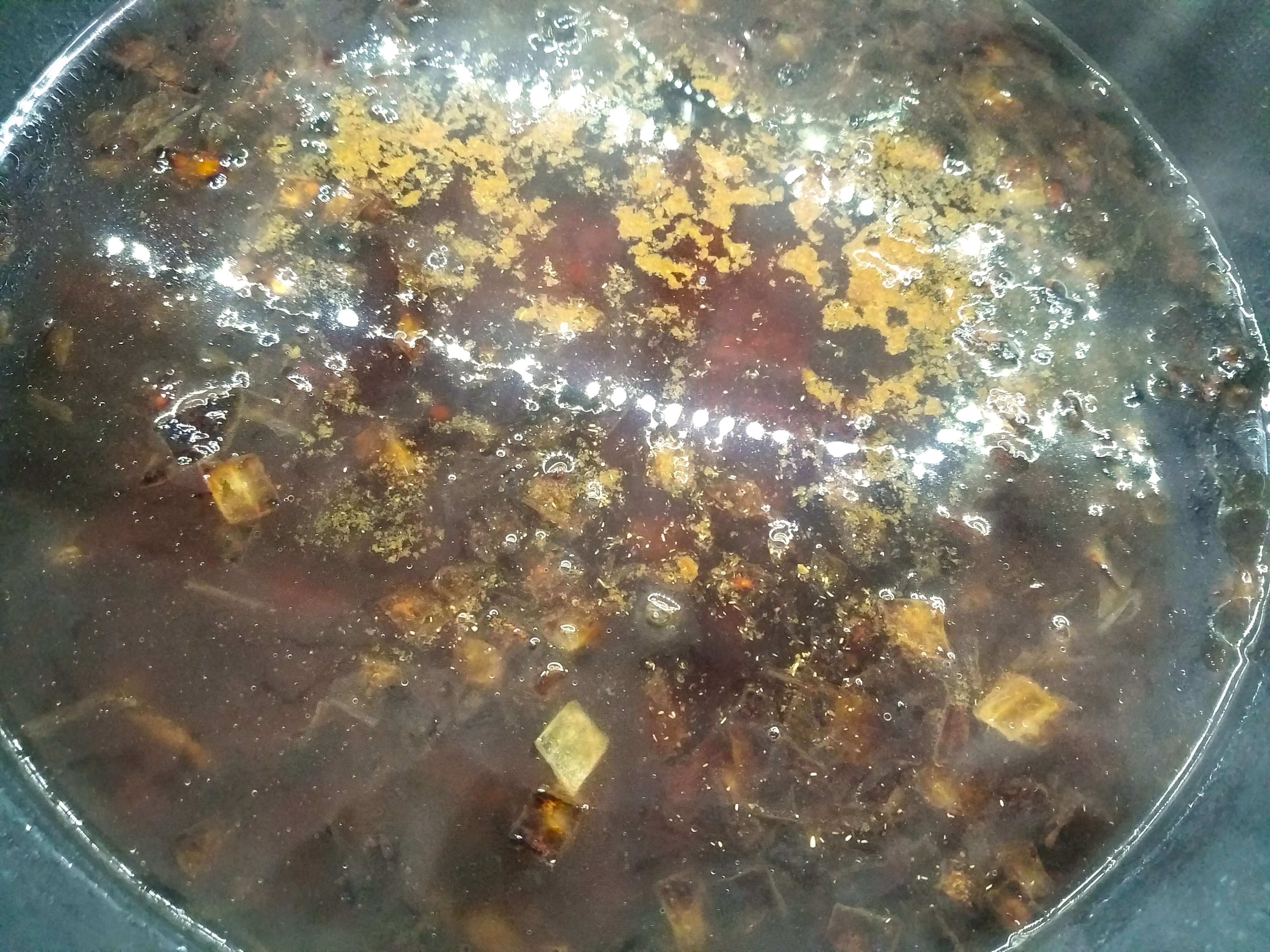 Boiling water, cumin, salt, and black pepper added to browned onions