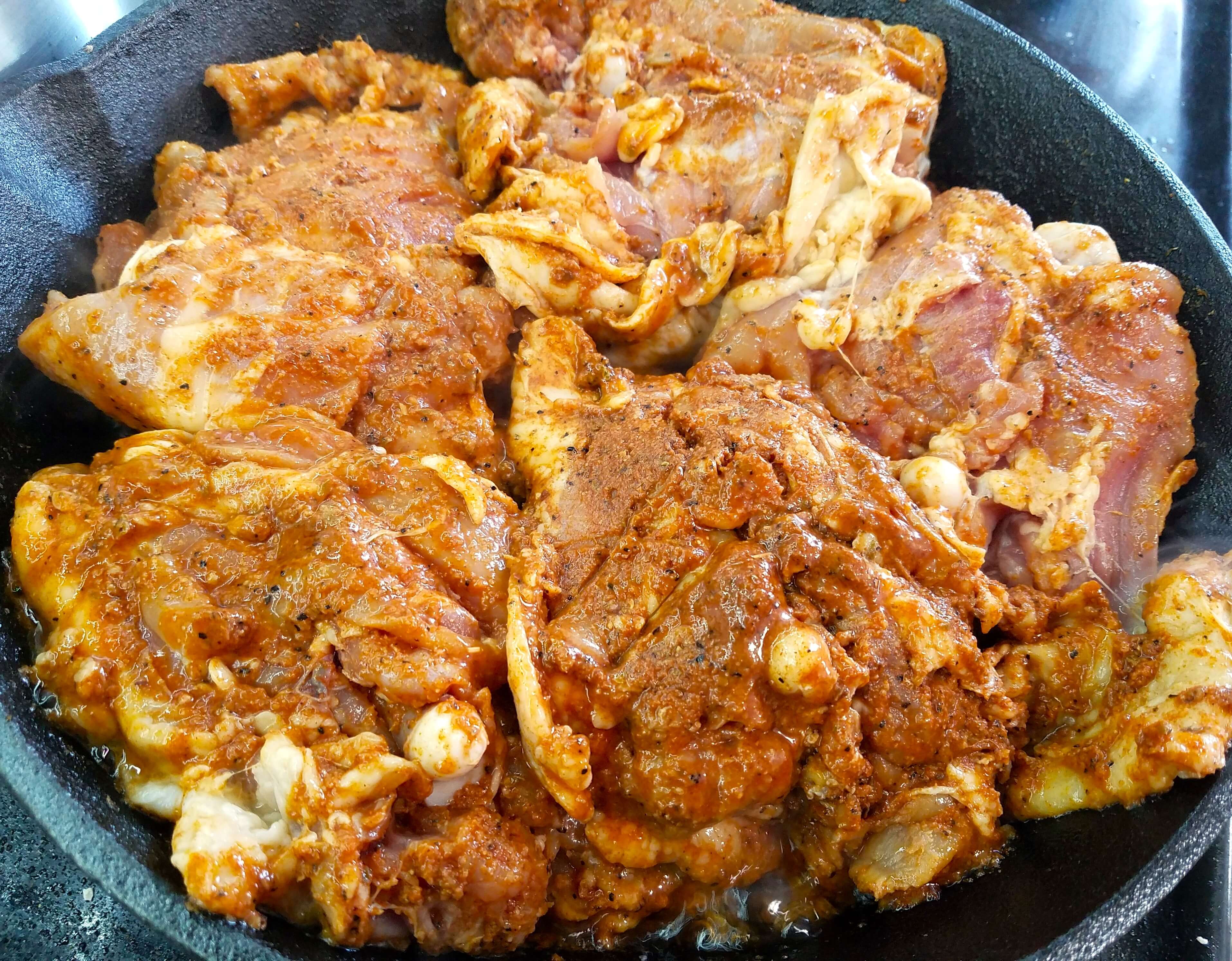 Chicken searing skin-side down in a hot skillet until golden and crisp